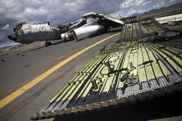 The wreckage of a military transport aircraft destroyed by Saudi-led airstrikes, at the Sanaa International airport, in Yemen, Tuesday, May 5, 2015. A Saudi-led coalition continues to bomb Shiite rebels also known as Houthis and allied forces across the country. The airstrikes campaign, which began on March 26, and the ground fighting have killed hundreds and displaced at least 300,000 Yemenis. (Photo by Hani Mohammed/AP Photo)