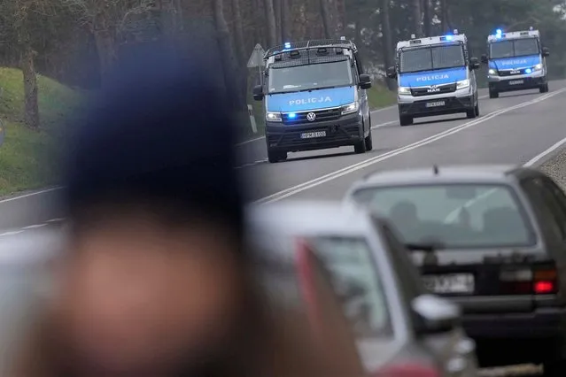 Polish police cars drive past a check point close to the border with Belarus near Kuznica, Poland, Tuesday, November 16, 2021. (Photo by Matthias Schrader/AP Photo)