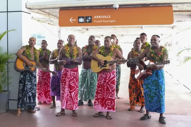 In this photo released by Tourism Fiji, guests receive a traditional Fijian welcome as they arrive at Nadi International airport in Fiji, Wednesday, December 1, 2021. Fiji welcomed back its first tourists in more than 600 days on Wednesday after deciding to push ahead with reopening plans despite the threat posed by the omicron variant. (Photo by Bruce Rounds/Tourism Fiji via AP Photo)