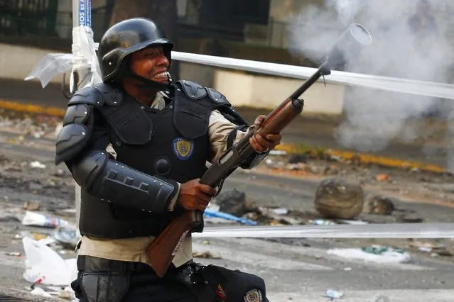 A riot policeman shoots tear gas at anti-government protesters during a protest in Caracas March 8, 2014. Latin American foreign ministers will meet next week to discuss the unrest in Venezuela that has left at least 20 dead and convulsed the South American OPEC nation, diplomatic sources said on Friday. (Photo by Carlos Garcia Rawlins/Reuters)