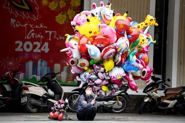 A balloon vendor waits for customers in Hanoi on February 15, 2024. (Photo by Nhac Nguyen/AFP Photo)