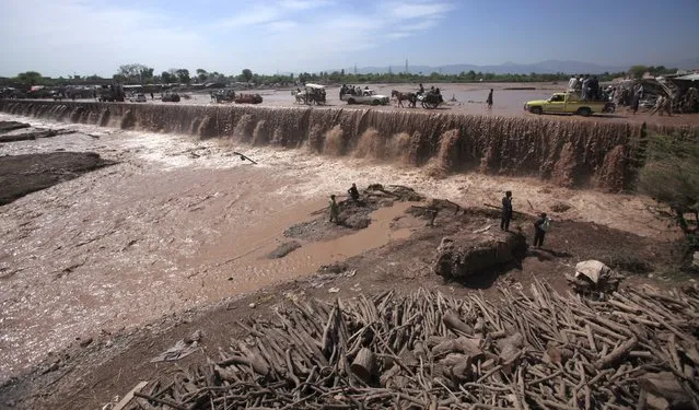 Residents use a bridge covered with floodwater in the Sarband area on the outskirts of Peshawar, Pakistan April 6, 2016. (Photo by Fayaz Aziz/Reuters)
