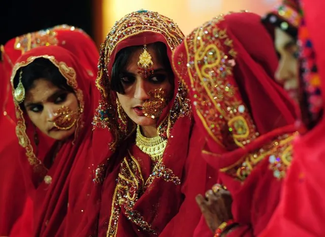 Pakistani brides talk as they attend a mass-wedding ceremony in Karachi on late March 24, 2014. Some 115 couples participated in the mass-wedding ceremony organised by a local charity welfare trust. (Photo by Asif Hassan/AFP Photo)