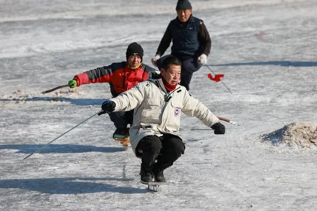 This photo taken on January 11, 2022 shows residents skating on a frozen lake in Shenyang in China's northeastern Liaoning province. (Photo by AFP Photo/China Stringer Network)