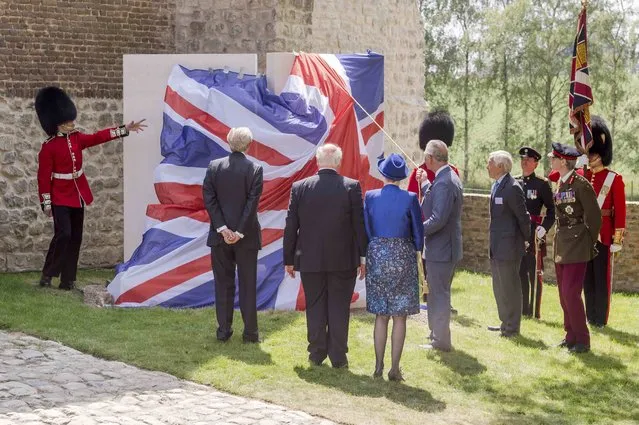 Britain's Prince Charles (4thL) holds a rope as he unveils a monument during a ceremony for the opening of the Hougoumont farm as part of the bicentennial celebrations for the Battle of Waterloo, near Waterloo, Belgium June 17, 2015. The commemorations for the 200th anniversary of the Battle of Waterloo will take place in Belgium on June 19 and 20. REUTERS/Geert Vanden Wijngaert/Pool