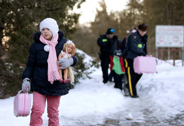 A young girl carries her doll and suitcase as her family that claimed to be from Turkey are met by Royal Canadian Mounted Police (RCMP) officers after they crossed the U.S.-Canada border illegally leading into Hemmingford, Quebec Canada March 20, 2017. (Photo by Christinne Muschi/Reuters)