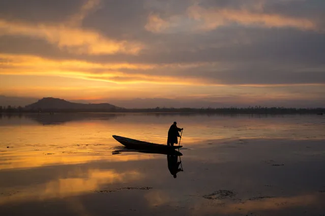 A Kashmiri fisherman rows his Shikara, or traditional boat, during sunset at the Dal Lake in Srinagar, Indian controlled Kashmir, Tuesday, March 29, 2016. Nestled in the Himalayan mountains and known for its beautiful lakes and saucer-shaped valleys, the Indian portion of Kashmir, is also one of the most militarized places on earth. (Photo by Dar Yasin/AP Photo)