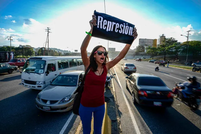 A student shouts slogans against Venezuelan President Nicola Maduro during a protest on the main highway in Caracas on March 30, 2017. Venezuela' s Supreme Court took over legislative powers Wednesday from the opposition- majority National Assembly, whose speaker accused leftist President Nicolas Maduro of staging a “coup”. (Photo by Juan Barreto/AFP Photo)