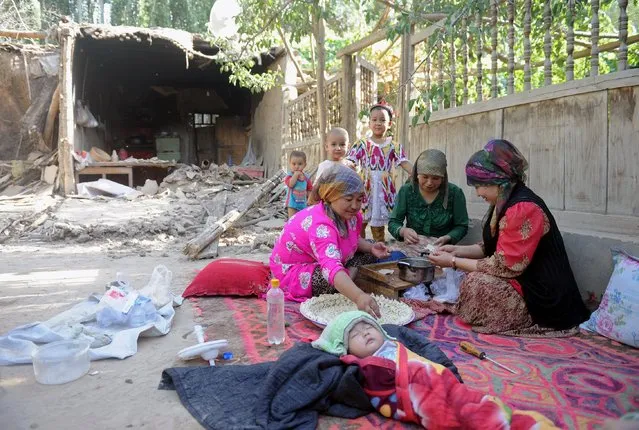 Women cook as a child sleeps near damaged houses, after an earthquake hit Hotan area, Xinjiang Uighur Autonomous Region, China, July 3, 2015. A strong earthquake hit a rural part of China's far western Xinjiang region on Friday, killing three people, injuring dozens and destroying or damaging thousands of homes, the government and state media said. (Photo by Reuters/Stringer)