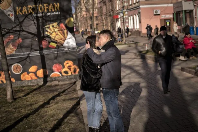 A couple kisses on a street in downtown Kyiv, Ukraine, Monday, February 14, 2022. (Photo by Emilio Morenatti/AP Photo)