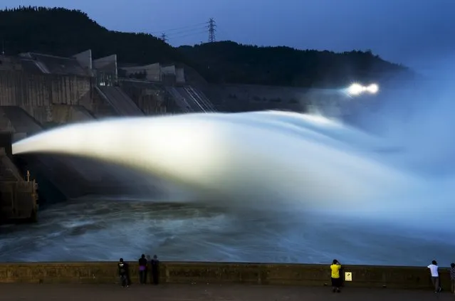 Visitors watch as water gushes from a section of the Xiaolangdi Reservoir on the Yellow River, in Luoyang, Henan province, China, July 4, 2015. (Photo by Reuters/Stringer)