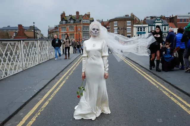 Lesley Scaife from Harrogate wears a wedding dress and painted face during the Goth weekend on April 26, 2014 in Whitby, England. The Whitby Goth weekend began in 1994 and happens twice each year. Thousands of extravagantly dressed people who follow Steampunk, Cybergoth, Romanticism or Victoriana visit the town to take part in the celebration of Goth culture.  (Photo by Ian Forsyth/Getty Images)