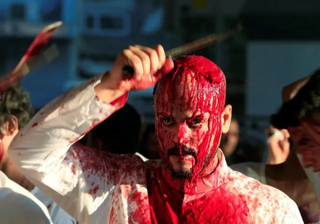 An Iraqi Shi'ite Muslim man bleed as he gashes his forehead with a sword and beat himself during a ceremony marking Ashura in Najaf, Iraq, September 10, 2019. (Photo by Alaa Al-Marjani/Reuters)