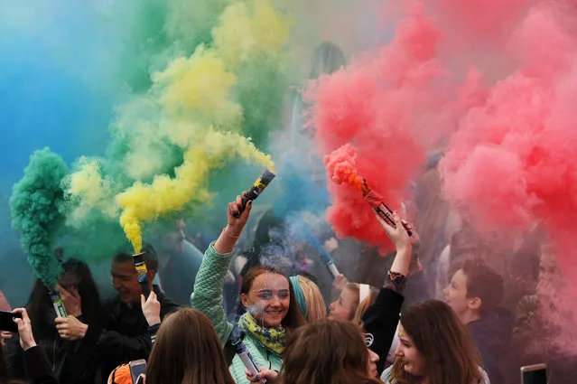 People holding coloured smoke flares take part in a festive event in Minsk on April 30, 2017. (Photo by Sergei Gapon/AFP Photo)