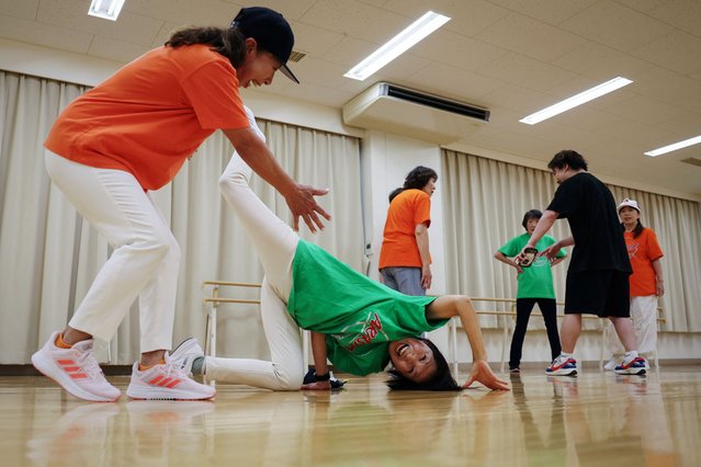 Reiko Maruyama (left), 71, encourages Mieko Nanba, 68, as she practices a breakdance move known as “chair freeze” during a training session with their team Ara Style Senior, Japan's only breakdancing club made up of elderly citizens, in Tokyo, Japan, on May 20, 2024. Born out of Maruyama's goal to energise the community through sports and excercise, Ara Style Senior now compromises about 15 members. “You can't help but laugh when you see yourself in these funny poses, | said the councilwoman. I think it's great that you can laugh, dance, and stay healthy, and that's why I recommend it to people around me”. (Photo by Kim Kyung-Hoon/Reuters)