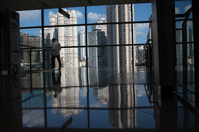 A man is walking inside a high-rise glass window shopping mall in Shanghai, China, on August 19, 2024. (Photo by Ying Tang/NurPhoto/Rex Features/Shutterstock)