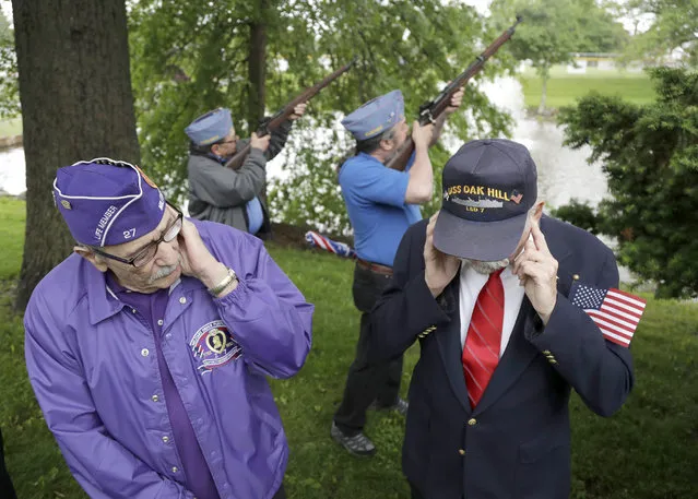 Herb Colie, left, who served with the 4th Battalion 60th artillery, and Jim Benning, rght, who served as a second class machinist's mate on the USS Oak Hill during the Vietnam War, cover their ears as John Marsigliano, back left, and Chris Moeller, both of the Sons of the American Legion, do a gun salute during a Memorial Day observance, Monday, May 29, 2017, in Bridgewater, N.J. (Photo by Julio Cortez/AP Photo)