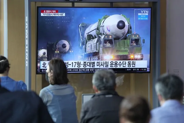 People watch a TV screen showing a news program reporting about North Korea's military parade with an image at a train station in Seoul, South Korea, Tuesday, April 26, 2022. North Korean leader Kim Jong Un vowed to move faster in bolstering his nuclear forces and threatened to use them if provoked in a speech he delivered during a military parade that featured powerful weapons systems targeting the country's rivals, state media reported Tuesday. (Photo by Lee Jin-man/AP Photo)