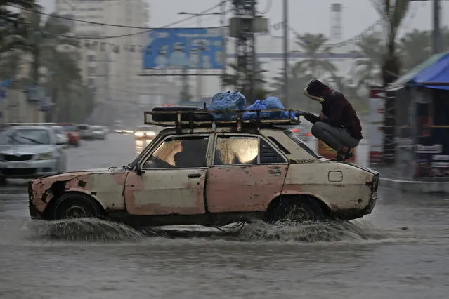 A car drives through a flooded road following heavy rain in Gaza City on December 27, 2019. (Photo by Mohammed Abed/AFP Photo)
