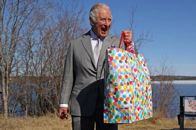 Britain's Prince Charles holds a bag as he reacts near the Great Slave Lake on the final day of his Canadian 2022 Royal Tour in Yellowknife, Northwest Territories, Canada on May 19, 2022. (Photo by Carlos Osorio/Reuters)