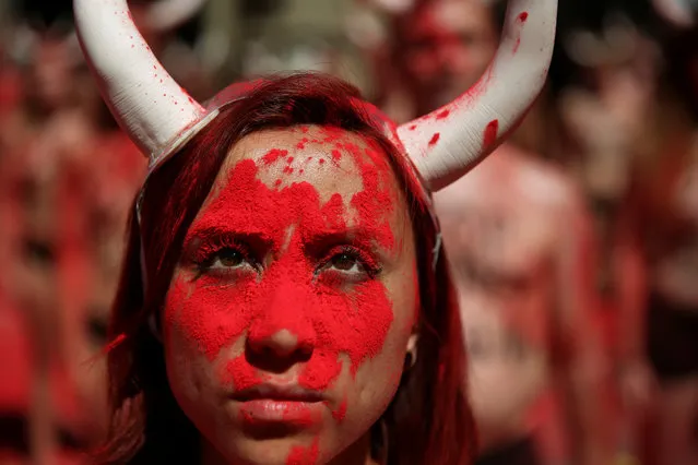 Animal rights protesters stand still after breaking mock banderillas containing red powder, which covered them during a demonstration for the abolition of bull runs and bullfights a day before the start of the famous running of the bulls San Fermin festival in Pamplona, northern Spain, July 5, 2017. (Photo by Susana Vera/Reuters)