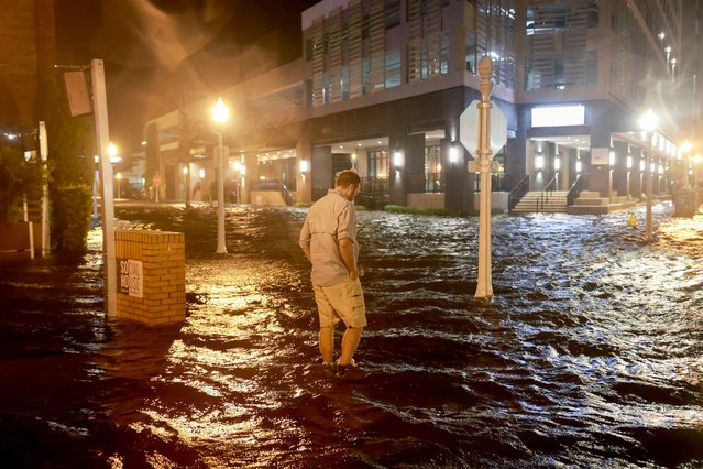 Brandon Marlow walks through surge waters flooding the street after Hurricane Milton came ashore in the Sarasota area on October 09, 2024, in Fort Myers, Florida. People are waiting to assess the damage after the Cat 3 hurricane came ashore. (Photo by Joe Raedle/Getty Images)