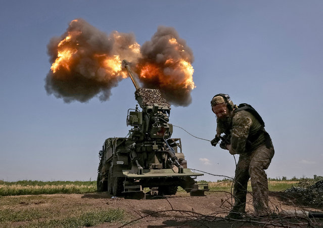 A Ukrainian serviceman of the 57th Kost Hordiienko Separate Motorised Infantry Brigade fires a 2S22 Bohdana self-propelled howitzer towards Russian troops, amid Russia's attack on Ukraine, at a position near the city of Bakhmut in Donetsk region, Ukraine on July 5, 2023. (Photo by Sofiia Gatilova/Reuters)