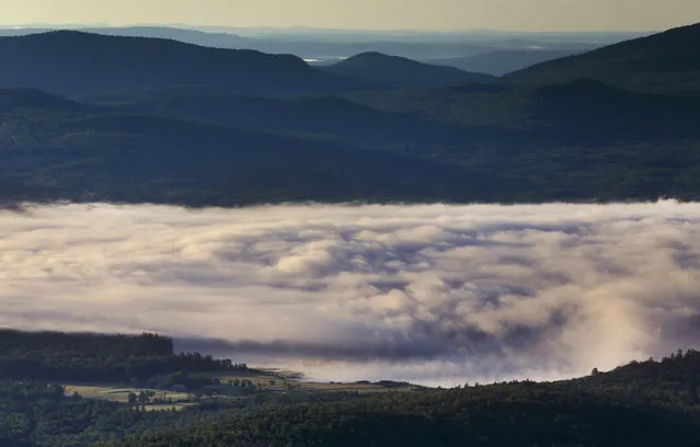 A billowy layer of fog hovers over Webb Lake on a chilly morning where the temperature dropped into the mid-40s, Wednesday, July 26, 2017, in Weld, Maine. (Photo by Robert F. Bukaty/AP Photo)