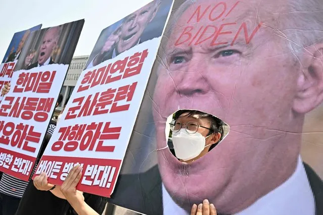 An activist protests against the visit of US President Joe Biden near the presidential office, where he is expected to hold meetings with South Korean President Yoon Suk-yeol in Seoul on May 21, 2022. (Photo by Anthony Wallace/AFP Photo)