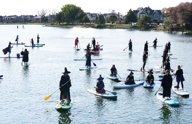 Dozens of people wearing witch costumes stand-up on paddle boards to take part in a Halloween float, at Spring Lake in New Jersey, United States on October 12, 2024. (Photo by Lokman Vural Elibol/Anadolu via Getty Images)