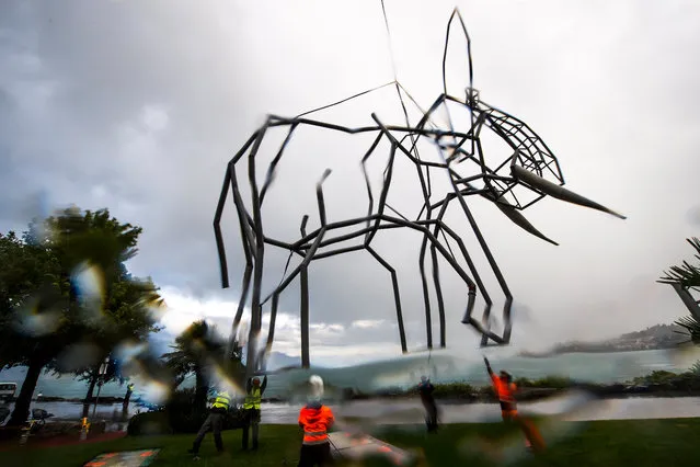 A sculpture shaped like an elephant, created by Swiss artist Dominique Andreae, is placed onto a base with a Super Puma helicopter prior to the start of the fifth Biennale of sculptures in Montreux, Switzerland, 25 July 2017. The elephant is made of steel and is 12 meters high, 15 meters long, 9 meters wide and weighs 3.7 tons. (Photo by Jean-Christophe Bott/EPA)