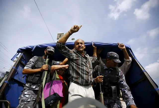 A protester chants slogans from a police vehicle while detained by Nepalese police during a general strike organised by a 30-party alliance led by a hardline faction of former Maoist rebels, who are protesting against the draft of the new constitution, in Kathmandu, Nepal August 16, 2015. (Photo by Navesh Chitrakar/Reuters)