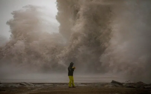A woman photographs the Mediterranean sea as the waves hit the breakwater during a storm in Barcelona, Spain, Tuesday, January 21, 2020. A winter storm lashed much of Spain for a third day Tuesday, leaving 200,000 people without electricity, schools closed and roads blocked by snow as it killed four people. Massive waves and gale-force winds smashed into seafront towns, damaging many shops and restaurants. (Photo by Emilio Morenatti/AP Photo)
