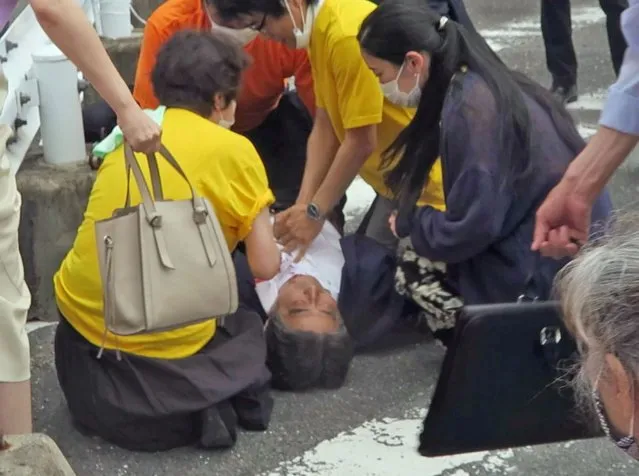 In this image from a video, Japan’s former Prime Minister Shinzo Abe, center, falls on the ground in Nara, western Japan Friday, July 8, 2022. Abe was shot during a campaign speech Friday in western Japan and was airlifted to a hospital but he was not breathing and his heart had stopped, officials said. (Photo by Kyodo News via AP Photo)