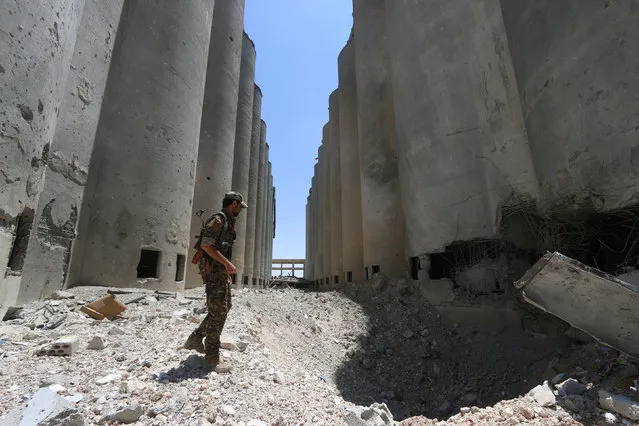 A Syria Democratic Forces (SDF) fighter walks in the silos and mills of Manbij after the SDF took control of it, in Aleppo Governorate, Syria, July 1, 2016. (Photo by Rodi Said/Reuters)