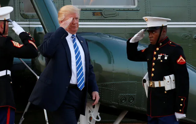 U.S. President Donald Trump returns a salute as he steps from Marine One to board Air Force One in Morristown, New Jersey, U.S., on his way back to Washington August 20, 2017. (Photo by Kevin Lamarque/Reuters)