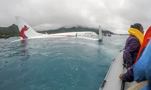 Passengers are evacuated from an Air Niugini plane that crashed into the sea on its approach to Chuuk international airport in the Federated States of Micronesia on September 28, 2018. All passengers were reportedly rescued safely from the partially submerged Boeing 737-800, after local fishers took their boats out to the crash site almost immediately. Locals reported that broken bones were among the passenger injuries after the flight came in “very low” for its landing, and ended up in the water. (Photo by Lt Zach Niezgodski/US Navy/AP Photo)