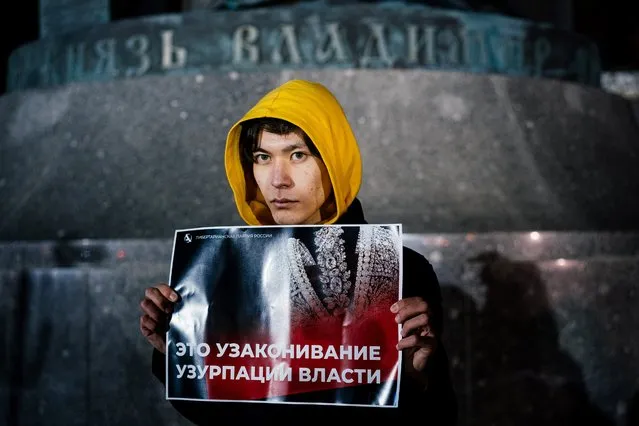 A woman holds a placard reading “This is the legitimisation of power's usurpation” as he demonstrates against the nullification of presidential term of Russian President in front of the monument to Vladimir the Great, near the Kremlin walls in central Moscow on March 10, 2020. Russian President Vladimir Putin laid out a path Tuesday to staying in power beyond 2024, as lawmakers approved sweeping reforms to the constitution. (Photo by Dimitar Dilkoff/AFP Photo)