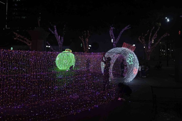 People set up Christmas decorations in Caracas, Venezuela, Tuesday, October 1, 2024. (Photo by Ariana Cubillos/AP Photo)
