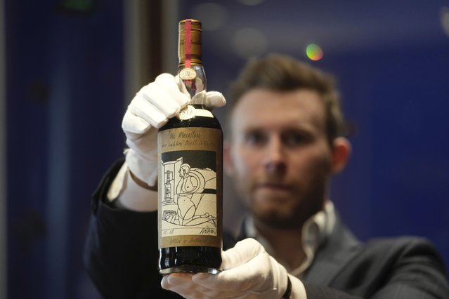 A bottle of the world's most valuable whisky is on display during a media preview of Sotheby's auction, in London, Thursday, October 19, 2023. After being aged in sherry casks for six decades, just 40 bottles of The Macallan 1926 were bottled in 1986. This bottle of whisky has an estimated price of $900,000-1,450,000. Advance bidding will open on Nov.1, 2023. (Photo by Kin Cheung/AP Photo)