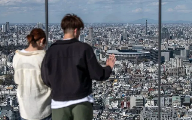 A man views the New National Stadium, the main stadium for the Tokyo 2020 Olympics, as he visits the Shibuya Sky observation deck on March 24, 2020 in Tokyo, Japan. Although an official decision is yet to be announced, International Olympic Committee member Dick Pound has said the Tokyo 2020 Olympic Games will be postponed by one year because of the Covid-19 coronavirus after the chairman of the British Olympic Association said Great Britain would be unlikely to send a team to Tokyo this summer while Australia and Canada also said they will not compete as the global Covid-19 coronavirus pandemic that has so far seen over 380,000 infections around the world forces countries to take drastic measures to protect their populations. (Photo by Carl Court/Getty Images)