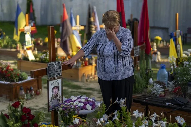 Hanna, 62, cries at the grave or her son Shufryn Andriy, 41, a Ukrainian serviceman who died in the war against Russia, at the cemetery in Lviv, Ukraine, Saturday, August 27, 2022. (Photo by Emilio Morenatti/AP Photo)