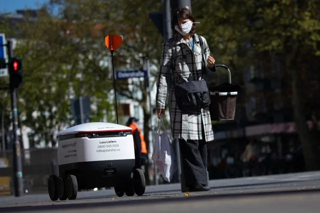 A delivery robot with food drives through the streets of Eimsbüttel area in Hamburg, Germany April 24, 2020, on its way from the organic food store “Bio.lose” to a customer. The Starship delivery robot, which has been upgraded with sensors, cameras, GPS and radar, brings food from retailers or restaurateurs to the customers. (Photo by Christian Charisius/picture alliance via Getty Images)