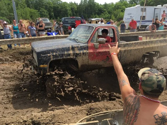 Spectators cheer as a pickup truck splashes through mud at an event formerly called the Redneck Olympics on Saturday, July 30, 2016, in Hebron, Maine. The organizer now calls the event the “Redneck Blank” after Olympic officials complained about the name. (Photo by David Sharp/AP Photo)