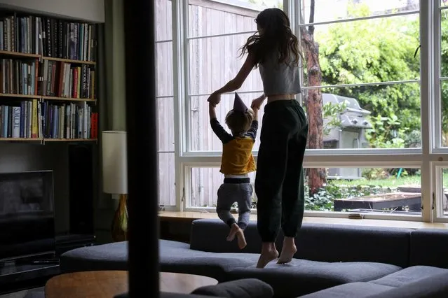 Jane Hassebroek jumps on the couch with her brother, Felix, while celebrating his birthday during the outbreak of the coronavirus disease (COVID-19) at their home in Brooklyn, New York, U.S., April 18, 2020. (Photo by Caitlin Ochs/Reuters)