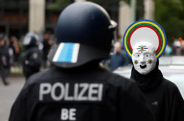 A protestor wearing a mask and a police officer face off during a demonstration on May Day, amid the spread of the coronavirus disease (COVID-19), in Berlin, Germany on May 1, 2020. (Photo by Christian Mang/Reuters)