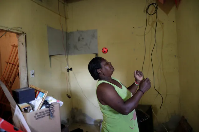 Sandra Regina, 53, who has lived in the Vila Autodromo slum for 20 years with her children, plays with a ball as the family moves to one of the twenty houses built for the residents who refused to leave the community, in Rio de Janeiro, Brazil, August 1, 2016. (Photo by Ricardo Moraes/Reuters)