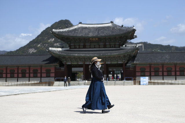 In this April 23, 2020 file photo, women wearing masks as a precaution against the new coronavirus, walk at the Gyeongbok Palace, in Seoul, South Korea. Nervous travelers, spotty air service, health risks – the battered global tourism industry is facing unprecedented uncertainty in the wake of the new coronavirus. Millions of workers are laid off or furloughed, and it will likely take years for the industry to get back to the strong demand it was seeing just six months ago. (Photo by Lee Jin-man/AP Photo/File)
