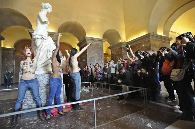Topless activists of the Ukrainian feminist group Femen demonstrate in front of the Aphrodite of Milos statue in the Louvre Museum, Paris, France, 03 October 2012, while people take photographs. Femen activists have become internationally known for organizing topless protests against s*x tourists, religious institutions, international marriage agencies, sexism and other social, national and international topics. EPA/YOAN VALAT