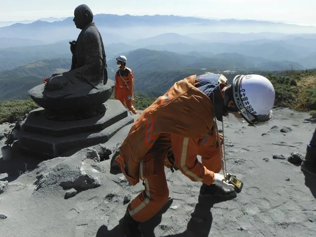 A firefighter checks toxic gas levels during rescue operations near the peak of Mt. Ontake, which straddles Nagano and Gifu prefectures, central Japan, in this handout photograph released by Nagoya City Fire Bureau and taken September 28, 2014. Search and recovery efforts for at least two dozen victims of Japan's worst volcanic eruption in decades were called off on Tuesday due to worries about rising volcanic activity, including the chance of another steam explosion. (Photo by Reuters/Nagoya City Fire Bureau)